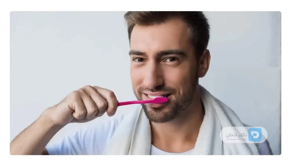 مردی که با مسواک نرم دندان های خود را تمیز می کند