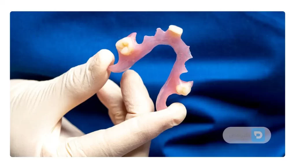 عکس دندان مصنوعی ژله ای در دست یک دندانپزشک